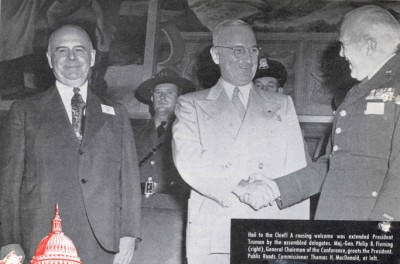 At the 1947 Highway Safety Conference, an honor guard of State police offers stood behind President Truman (center) while he spoke. General Fleming (right) and Commissioner of Public Roads Thomas H. MacDonald greeted the President on stage