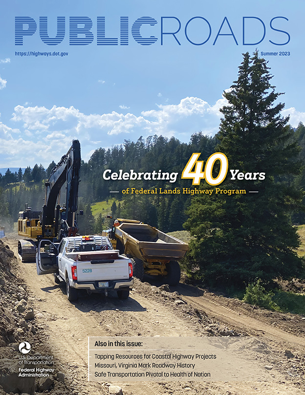 A fleet truck, excavator, and haul truck cut a road through dirt and rock on the top of a mountain. Evergreen trees surround the work site, with mountains in the distance. Image Source: FHWA.
