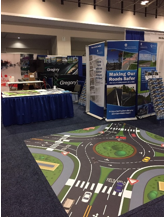 A 10x10 roundabout floor decal in front of the FHWA Office of Safety TRB booth.