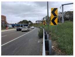 This photo shows a curving interstate roadway featuring chevrons and high friction surface treatment.