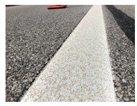 Close-up photo of a recessed highly reflective polyurea pavement marking.