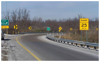 Photo of a roadway featuring fresh retroreflective markings and bright new chevrons to delineat the road.