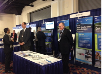 Nick Artimovich and Ray Krammes staff the booth while Karen Scurry gives a demo of the Systemic Tool.