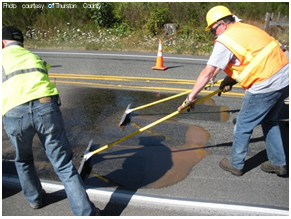 Thurston County's crew prepared the resin, applied it to the road, and covered it with a specialized calcined bauxite aggregate at this HFST project in 2014