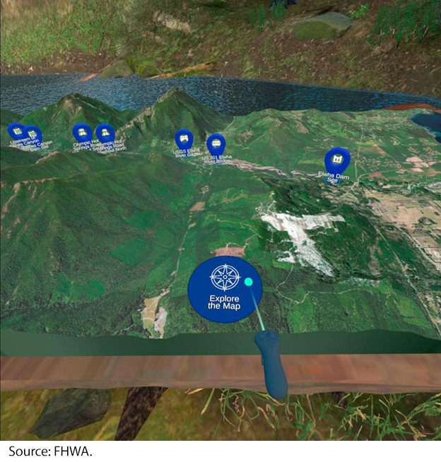 "Screenshot from a virtual reality simulation shows a diorama (or three-dimensional model) of a long reach of the Elwha River in Washington State. The river reach lies within a valley between mountain ridges. Several locations in the diorama are labeled, coinciding with two dam removals, the U.S. 101 bridge, and other points of interest. Image Source: FHWA."