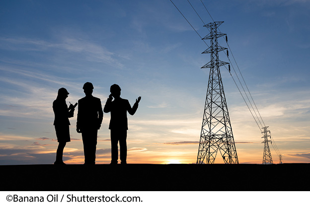 "A  photo of utility managers with utility transmission and sunset behind them. Photo Source: ©Banana Oil / Shutterstock.com."