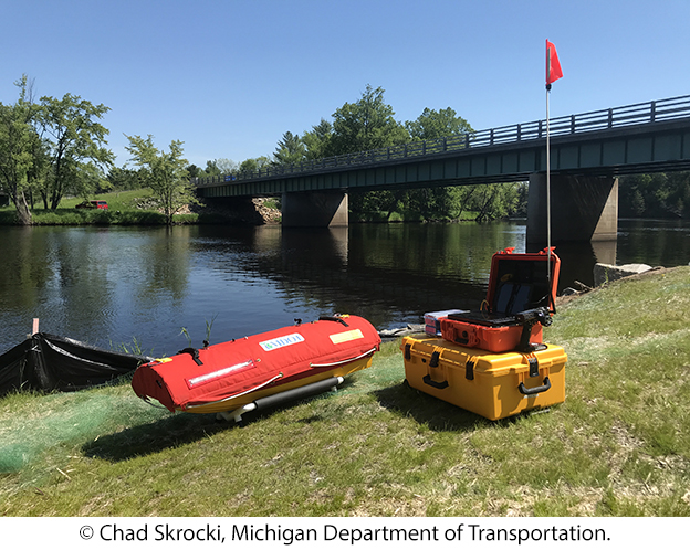 The unmanned surface vehicle on land beside the operator's equipment. © Chad Skrocki, Michigan Department of Transportation.