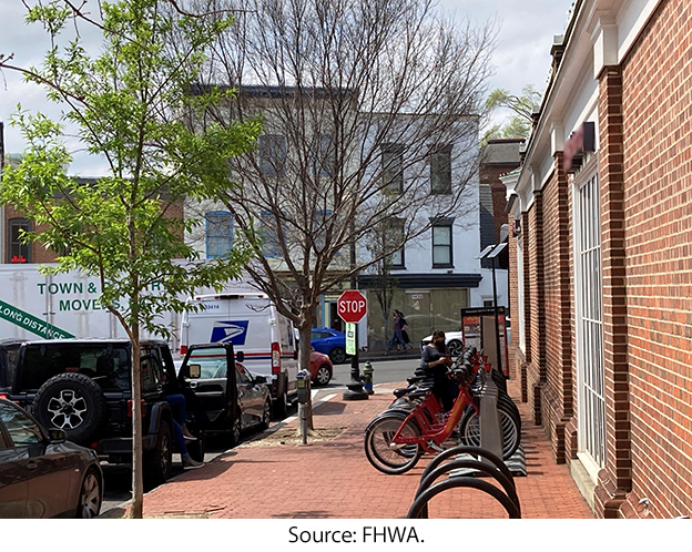 A sidewalk with a bike rack and a bikeshare dock. Source: FHWA.