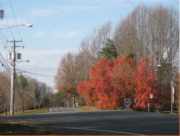 "A rural roadway where the road topography prevents drivers approaching an intersection from opposite directions to see each other clearly."