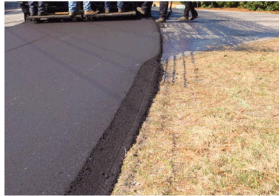 Close-up photograph of a new pavement with safety edge and without the safety edge. The pavement edge of the shoulder adjacent to the clear zone is shaped into a 30-degree wedge. Safety edge is not used when the roadway intersects with crossroads. Part of the way down, the pavement edge of the shoulder goes back to 0 degree.