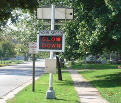 "This is a photo of an automatic speed warning sign showing SLOW DOWN in a neighborhood area."