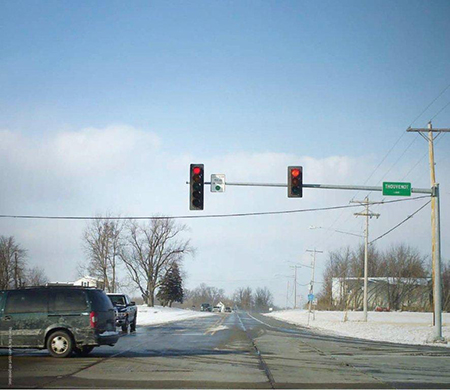 "Early morning photograph of a rural road with non-flashing traffic lights"