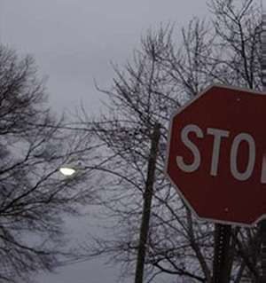 "Photograph of a stop sign illuminated by a street light"