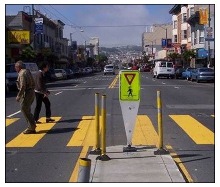 Photograph of a pedestrian sign mounted in the cement on a median strip.