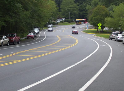 "A segment of roadway that includes parallel parking on both sides, dedicated bike lanes, and a center turn lane."