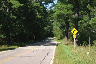 Page 24 photo. This image shows a two lane road with no shoulder.