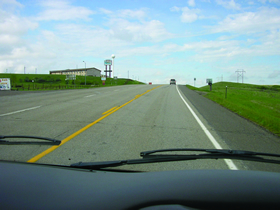 Photo 3 is a two-lane road surrounded by farmland.