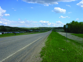 Photo 2 shows a two-lane road with very little development. 