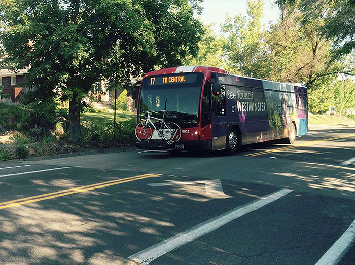 Figure 5.3. Bus Passing Over a Speed Hump. This figure contains a photograph of a tree-lined residential street with a bus passing over a speed hump.