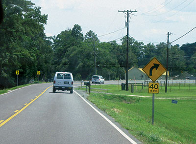 FHWA's Low-Cost Treatments for Horizontal Curve Safety includes numerous options for transportation departments, including placing chevron signs (at left) in combination with curve and speed signs, as shown here.