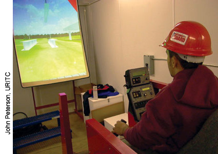 Under the direction of an instructor, this student is lifting an I-beam into place using a crane simulator. This mobile training unit enables participants to simulate operating heavy equipment in a safe environment at a fraction of the cost of using an actual crane.