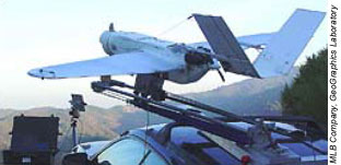 An unmanned ariel vehicle shown on a platform, in launch position with mountains and sky in the background