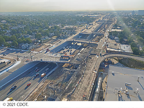 Aerial view of Interstate 70 viaduct as vehicles travel on a recently built section and an older portion is removed. Image Source: © 2021 CDOT.