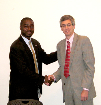 Emeka Moneme and Mark Kehrli shaking hands after the historic signing.