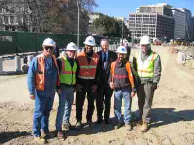 Former President George H. W. Bush visited the Pennsylvania Avenue construction zone in March 2004. This photo was taken on Pennsylvania Avenue next to the west entrance to the White House. From left to right: Chris Dupont (consultant inspector), John Roddy (Project Manager for Lane Construction Company), Mike Tyree (FHWA), former President Bush, Jorge Alvarez (FHWA Project Engineer) and Gerald Rench (consultant inspector). (Photo courtesy Eastern Federal Lands Highway Division.)